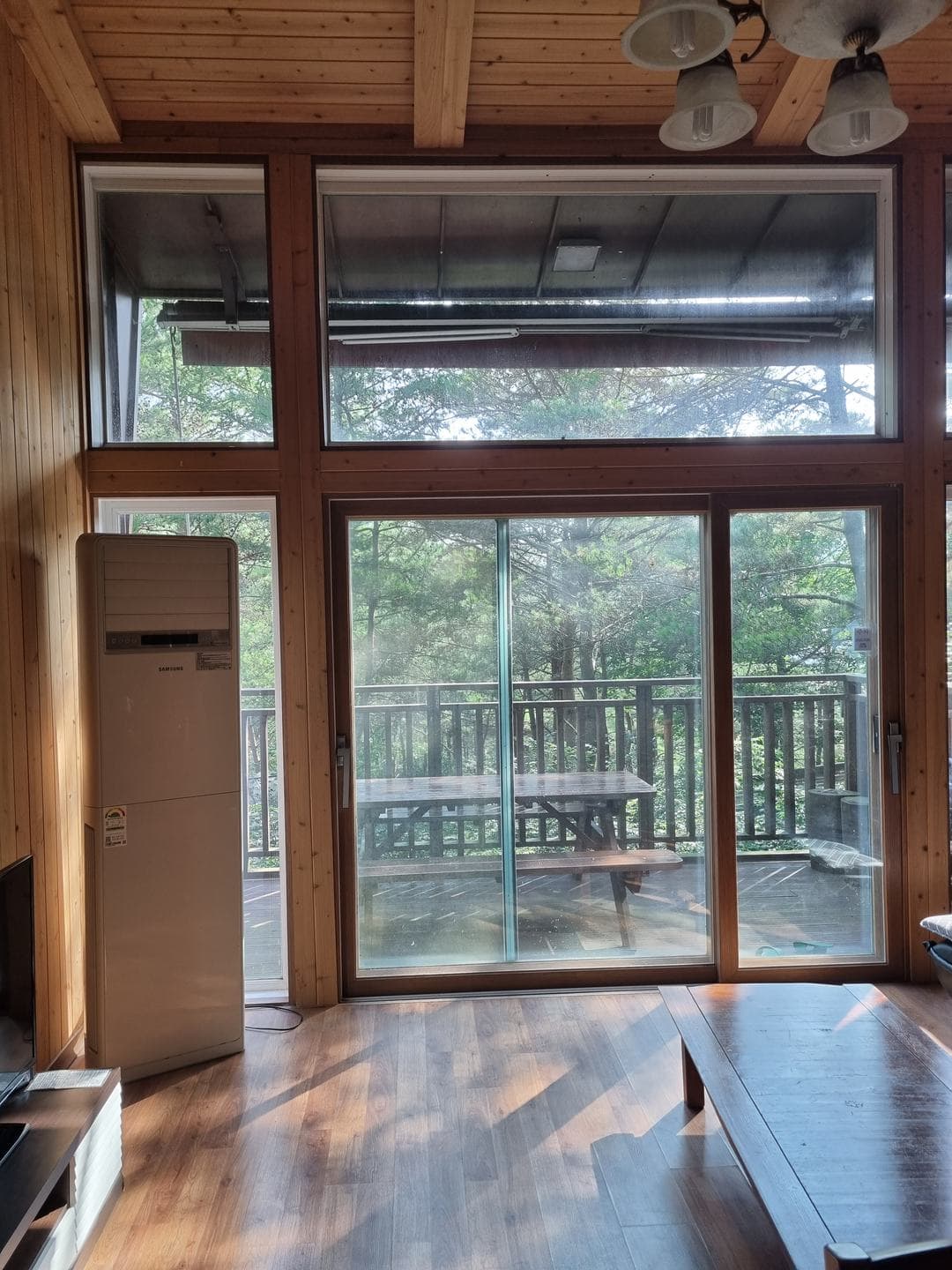 Inside the cabin: wooden floors and a tall window onto the deck