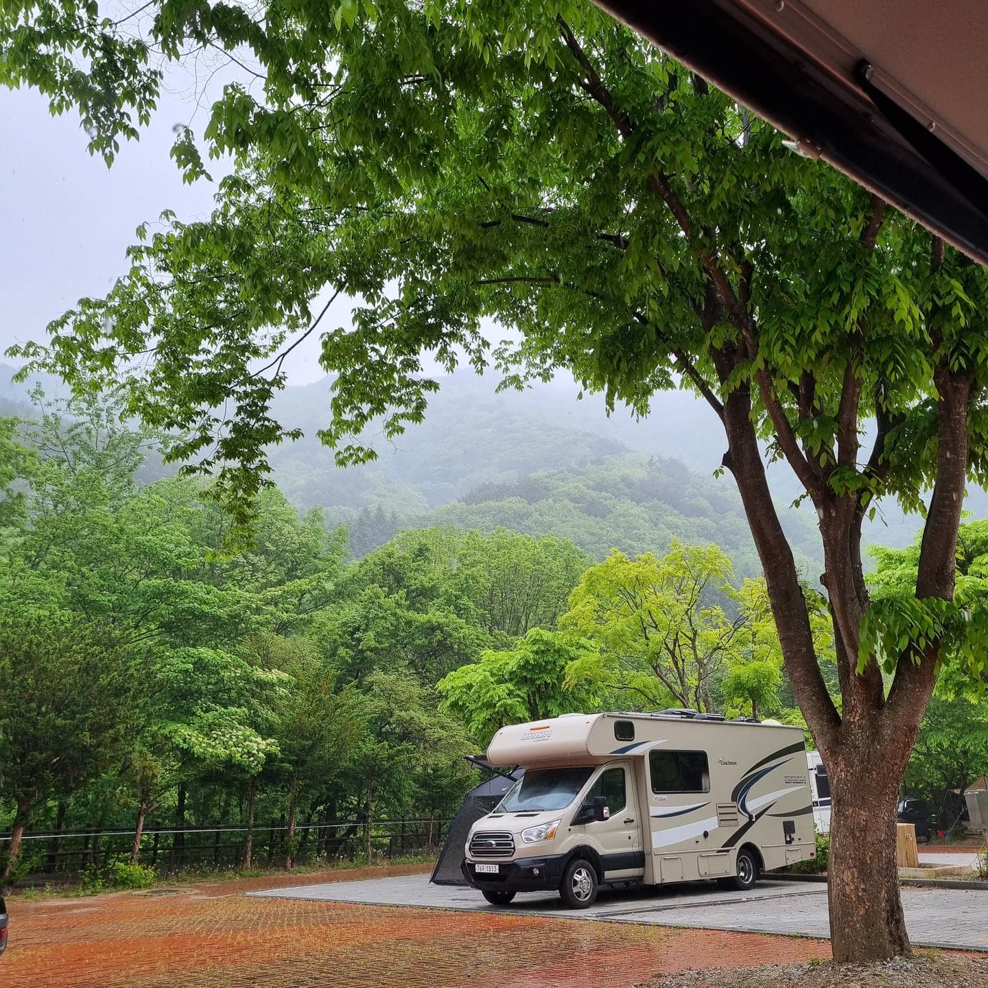 A camper van parked under a tree in the Gucheondong valley