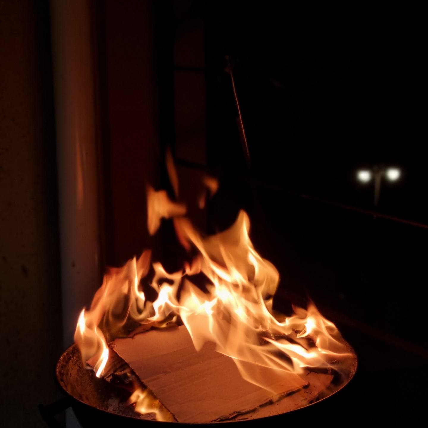 A fire burning down in the dark