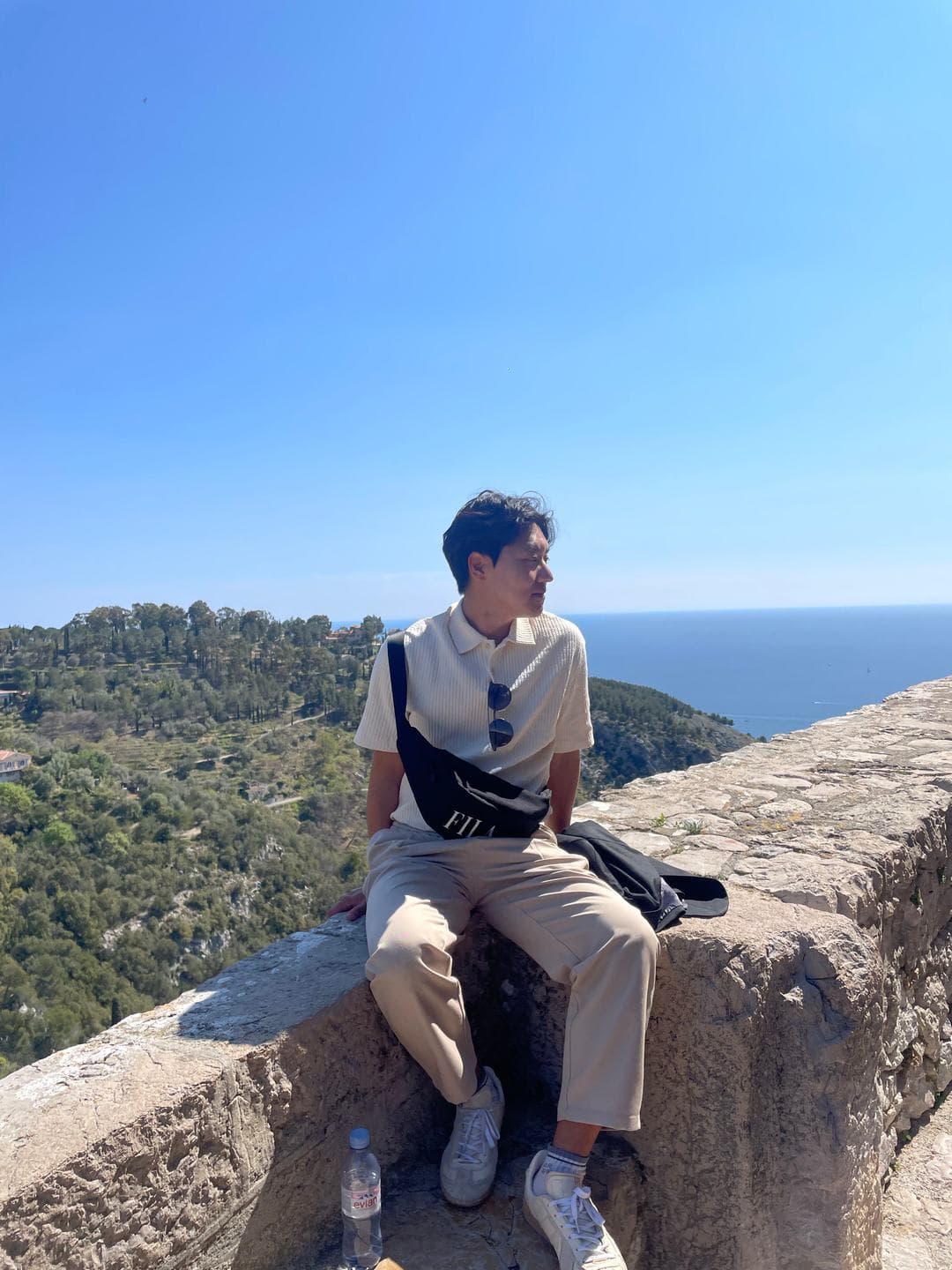 Sitting on the old stone wall with the Mediterranean behind