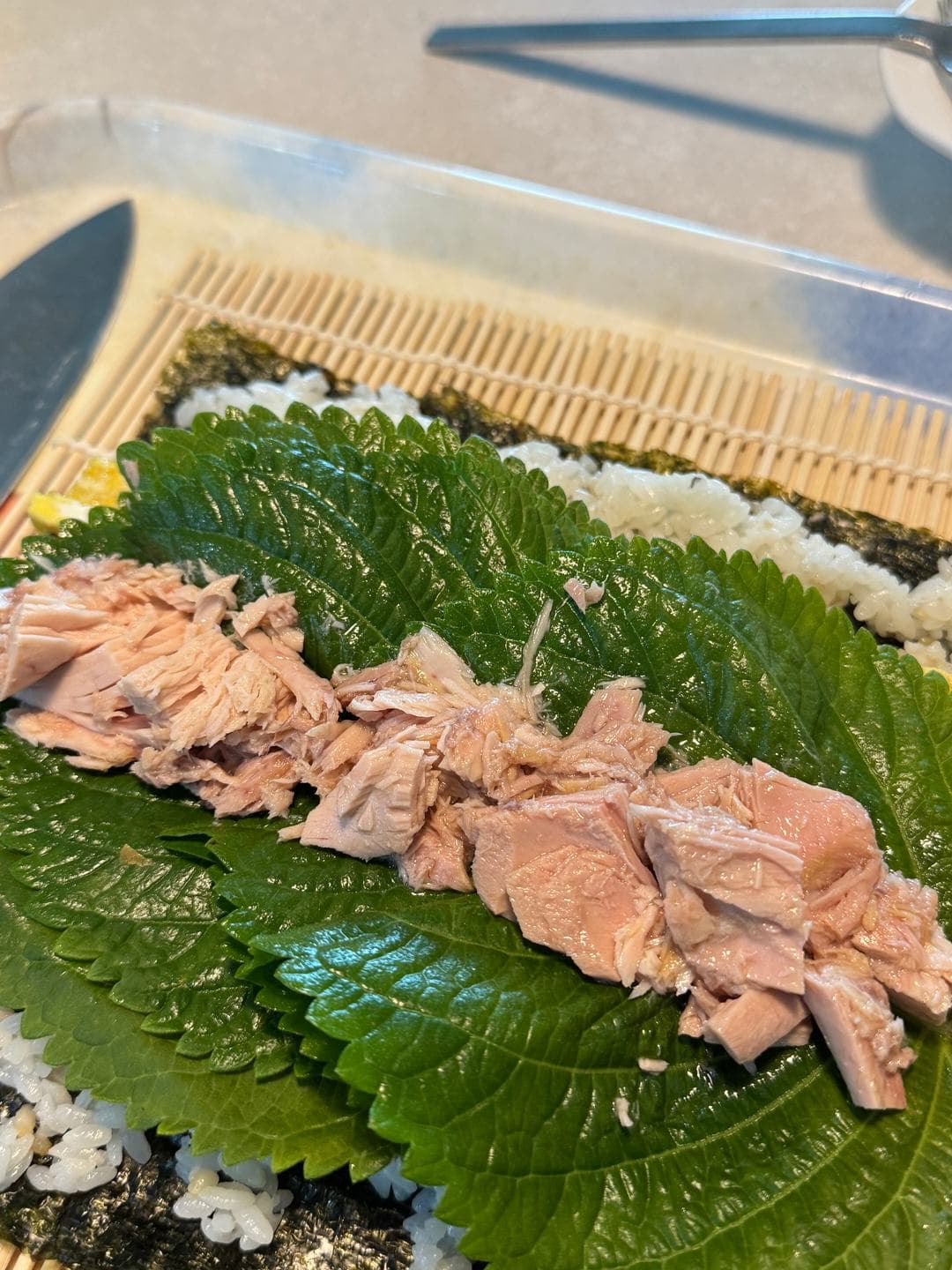Perilla leaves and tuna laid on rice and seaweed for gimbap