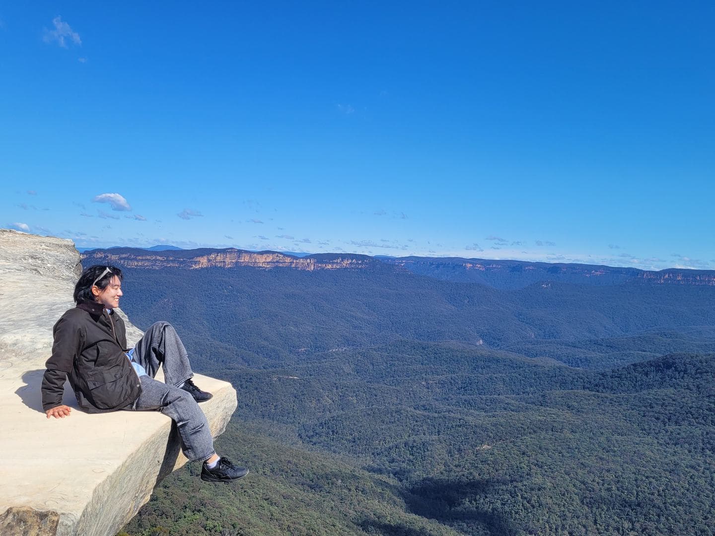 Feet over the edge, the valley spreading out below
