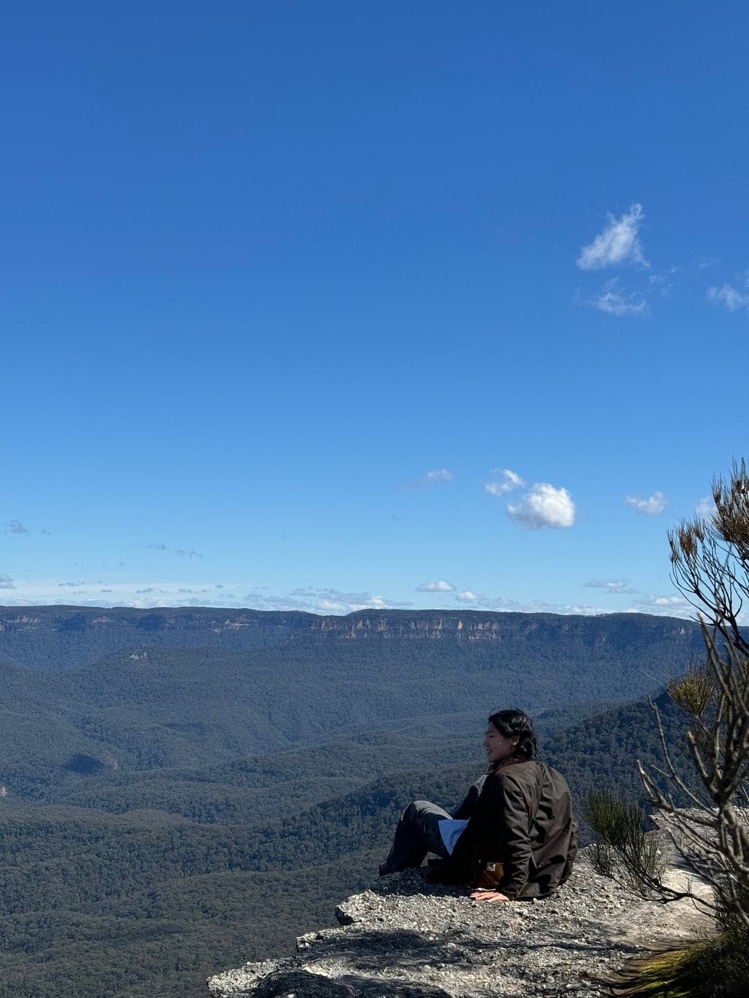 Sitting on the rocks with the far cliffs on the horizon