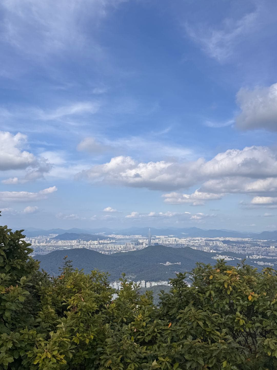 Big September clouds over the city and green hills