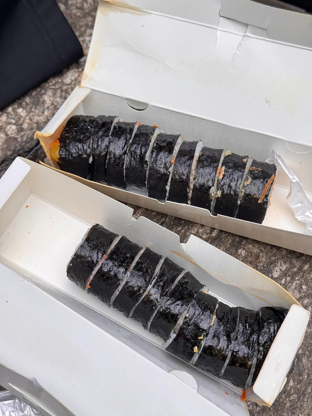 Two boxes of gimbap on a rock