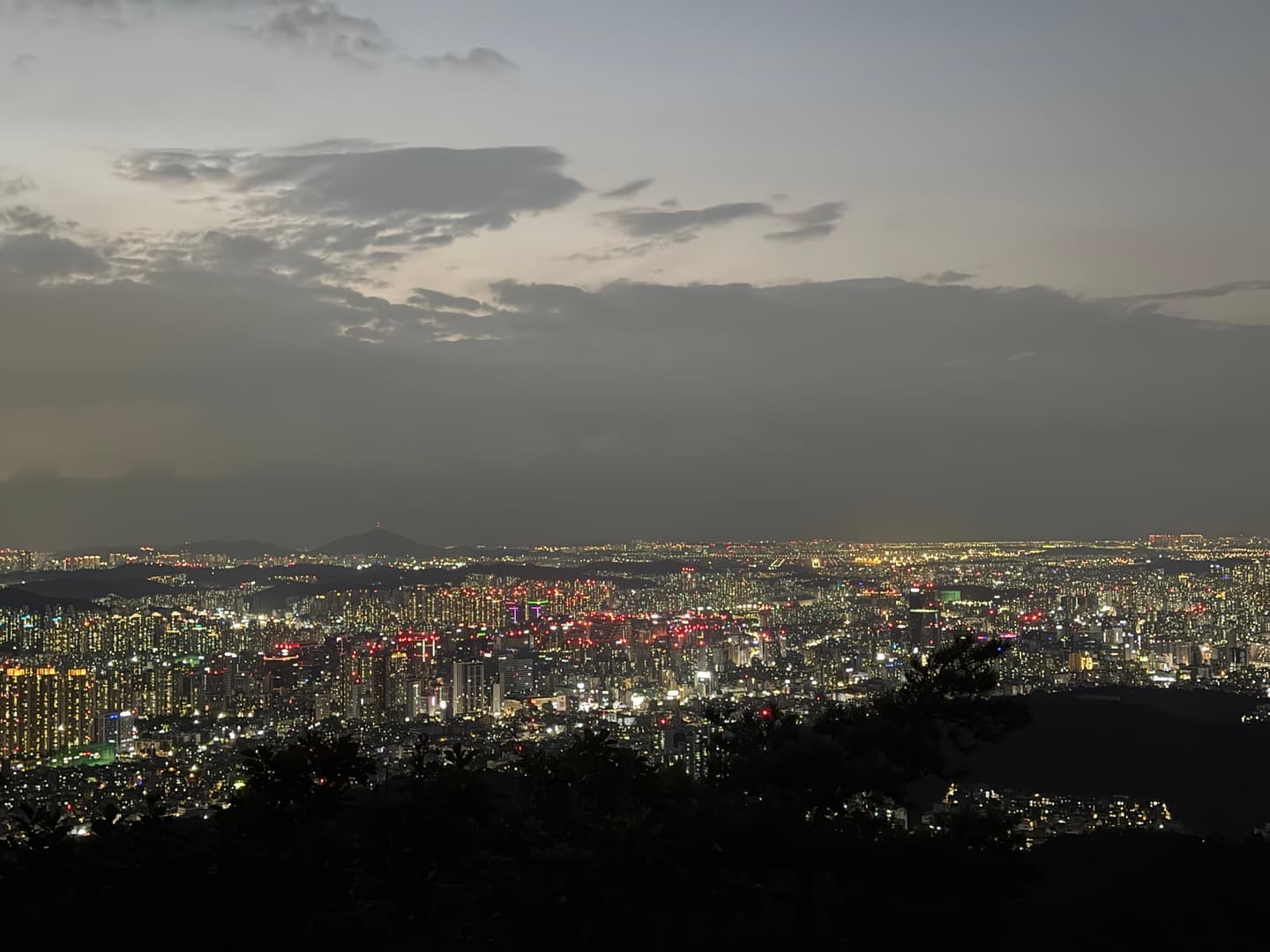 Seoul at night stretching to the horizon under the last light