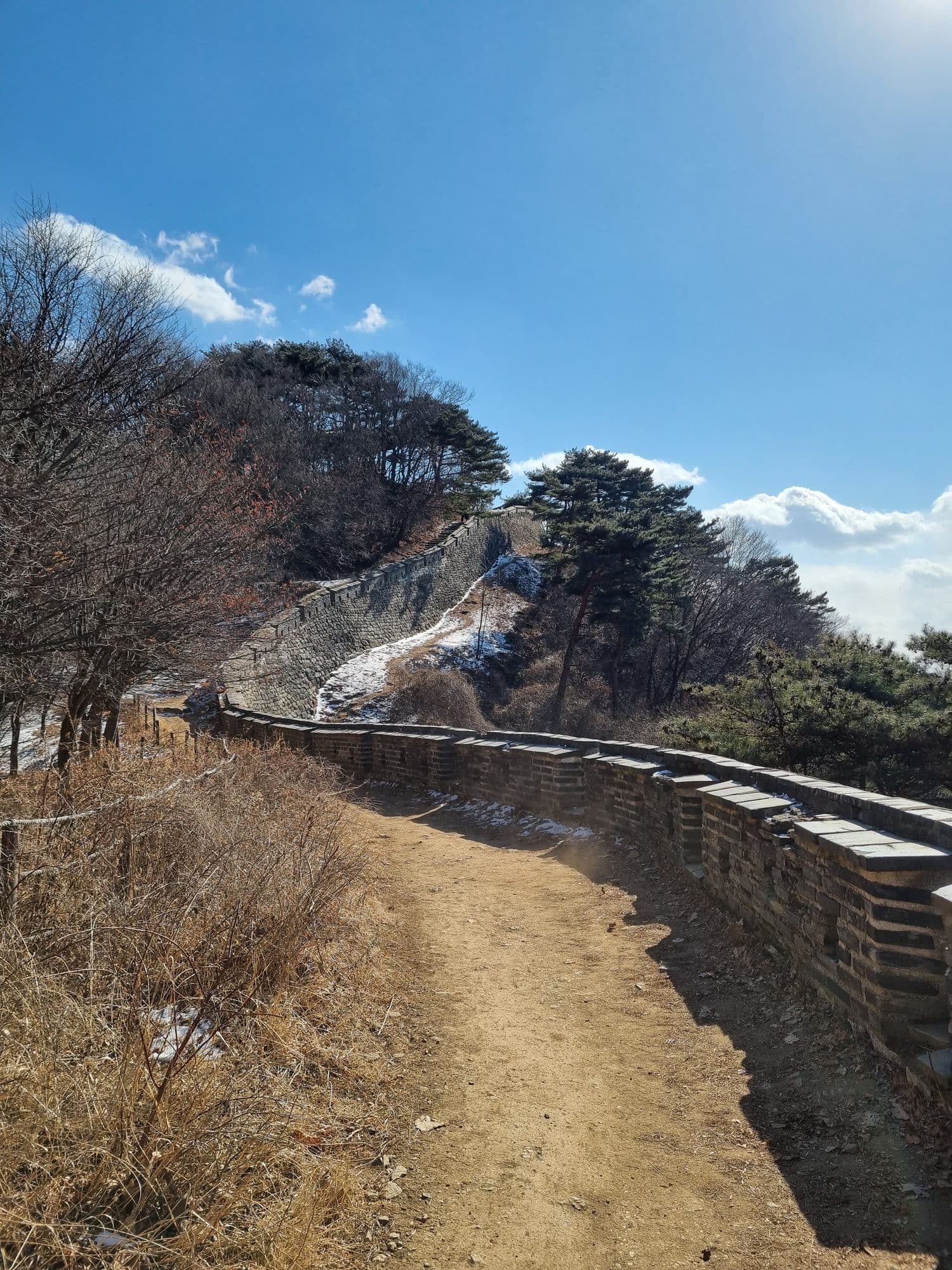 The fortress wall trail running along the ridge under a bright winter sky
