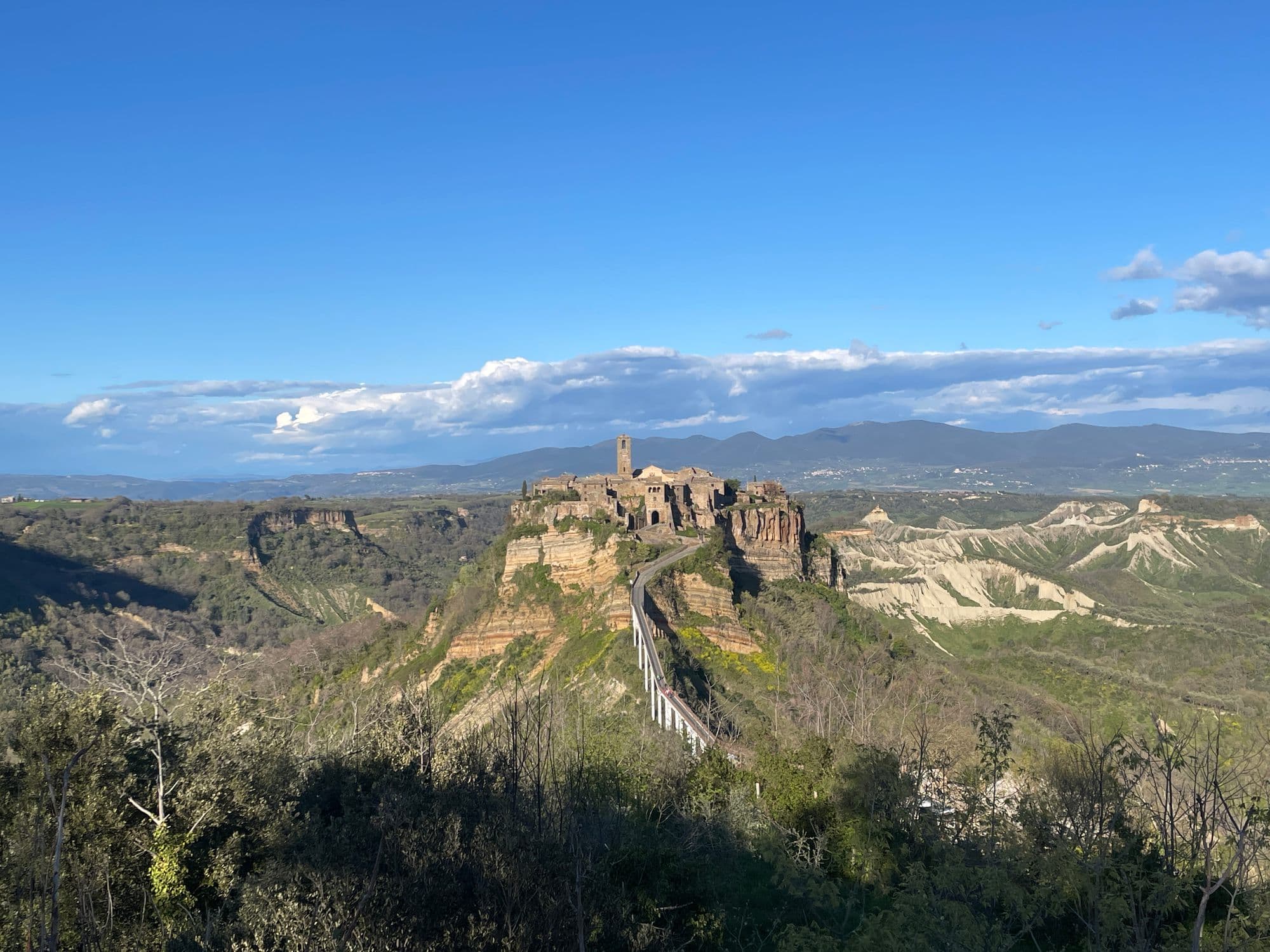 Civita di Bagnoregio on its tuff pillar, the footbridge climbing to it in late light